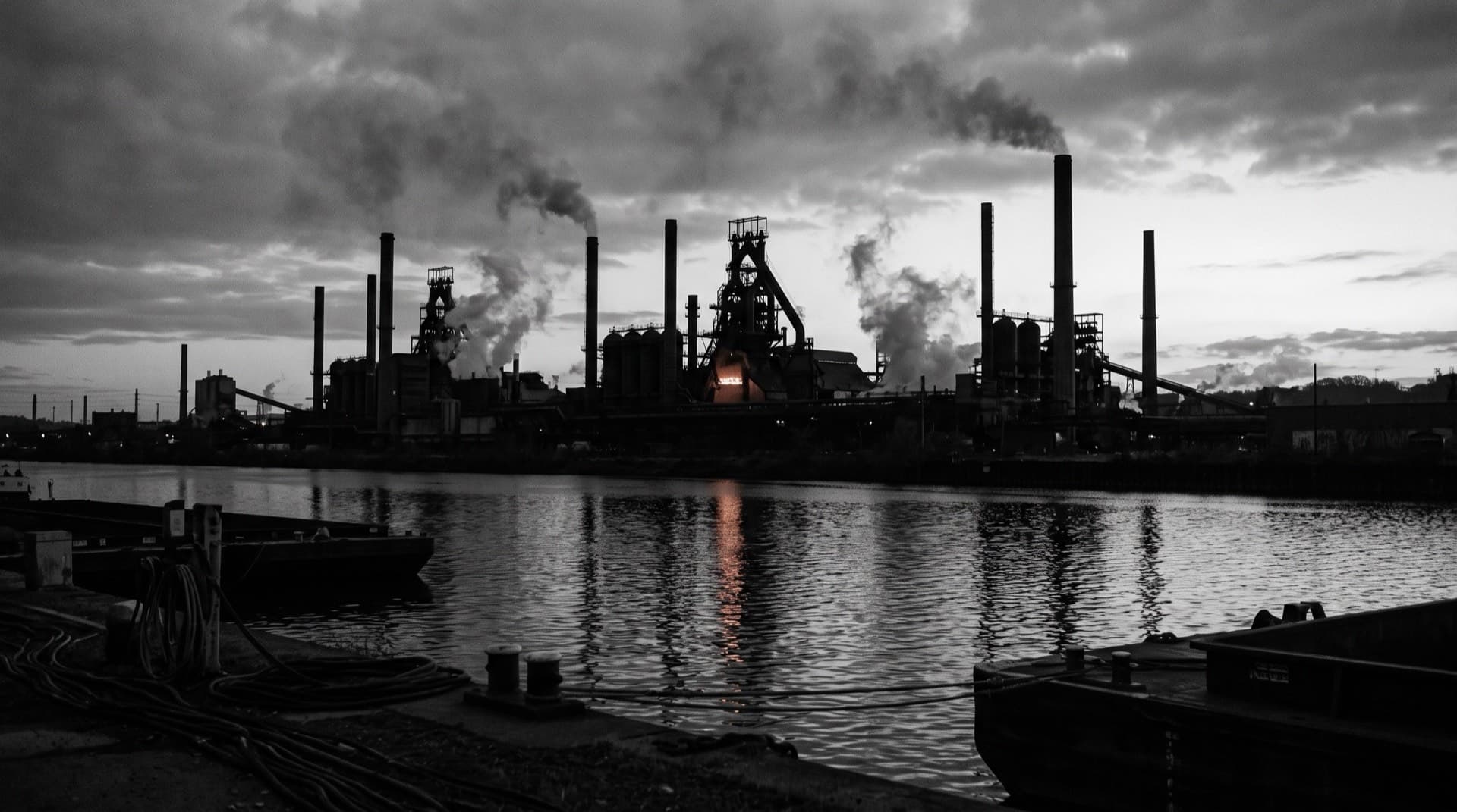 A steel mill skyline reflected in a dark river at dusk (photo illustration)