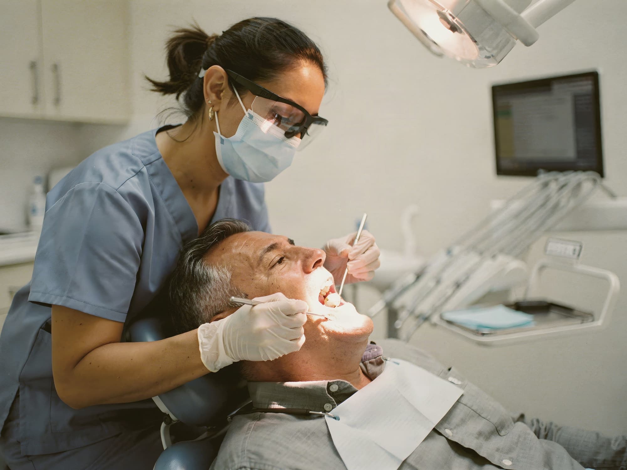 man in a dental chair talking with his dentist